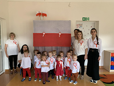 Dzieci stoją razem z Paniami ubrane w stroje biało – czerwone