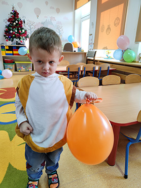 Zdjęcie przedstawia chłopca z balonikiem.