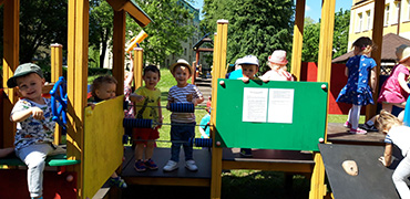 Zdjęcie przedstawia grupę dzieci bawiące się na placu zabaw.