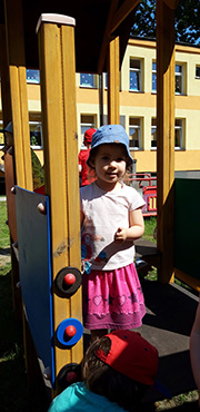 Zdjęcie przedstawia dziewczynkę na placu zabaw.