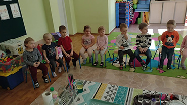 na zdjęciu widać siedzące dzieci na krzesełkach
