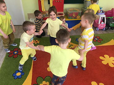 dzieci tańczą w kole do piosenki Pszczółka Maja - ,,Taniec Mai”
