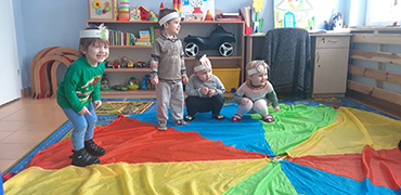 Na zdjęciu widać czworo dzieci bawiące się przy piosence pt ”spacer krasnoludka”