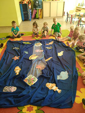 dzieci oglądają zwierzęta mieszkające w kolorowej podwodnej krainie