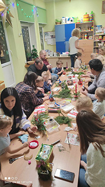 Rodzice razem z dziećmi wykonują stroiki świąteczne
