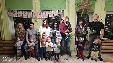 Rodzice i dzieci prezentują wykonane wspólnie ozdoby bożonarodzeniowe